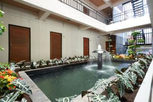 坤敬艾昂吉特池尔房屋酒店的一座建筑中间的游泳池,有一个喷泉
