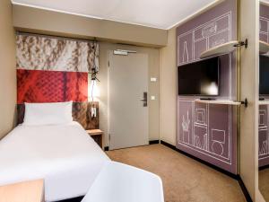 慕尼黑慕尼黑宜必思酒店的配有一张床和一台平面电视的酒店客房