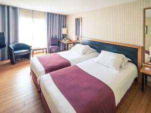 蒙彼利埃蒙彼利埃安提戈涅中心美居酒店的酒店客房设有两张床和电视。