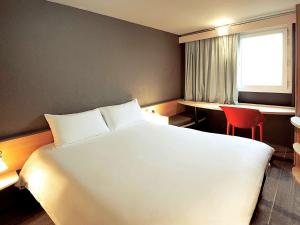 欧布纳奥贝纳斯宜必思酒店的卧室配有一张白色大床和红色椅子