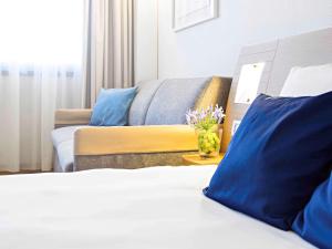 热那亚诺富特热那亚欧维斯特酒店的酒店客房,配有床和沙发