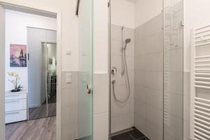 伯尔格伦德-雷特维施Residenz Am Meer的带淋浴的浴室和玻璃门