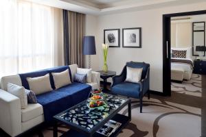 利雅德voco - Riyadh, an IHG Hotel的客厅配有蓝色的沙发和桌子