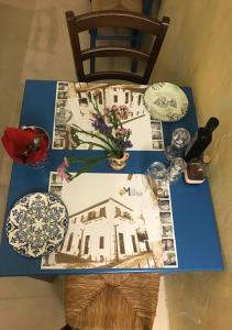 帕福斯Casa Mespilea的一张蓝色桌子和一幅房子的照片
