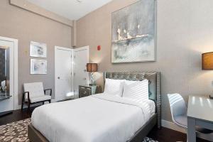 波士顿Bay Village Suites的卧室配有一张白色大床和一张书桌