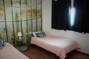 阿亚蒙特Aloja Ayamonte的卧室配有一张床,墙上挂有绘画作品
