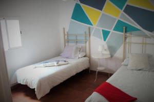 阿亚蒙特Aloja Ayamonte的客房设有两张床和彩色墙壁。