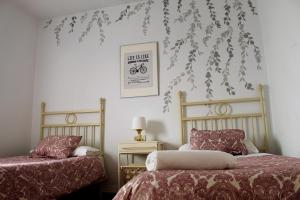 阿亚蒙特Aloja Ayamonte的卧室配有两张床,墙上挂着一张自行车的照片