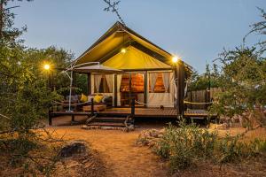 侯斯普瑞特Mountain View Safari Lodge的田野上带一张床的豪华帐篷