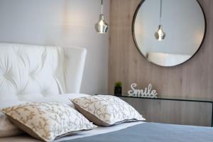 扎达尔Shell Luxury Residences with Pool and Whirlpool的一间卧室配有一张带两个枕头和镜子的床