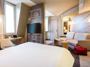 巴黎朗东堡10号巴黎北站宜必思酒店的酒店客房,配有床和沙发
