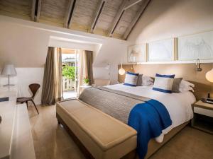 卡塔赫纳索菲特传奇圣克拉拉卡塔赫纳酒店的大卧室配有一张带蓝色枕头的大床