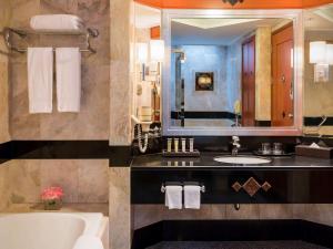 坤敬Pullman Khon Kaen Raja Orchid的带浴缸、水槽和镜子的浴室