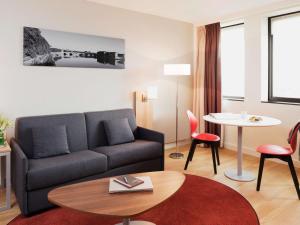 图卢兹Aparthotel Adagio Toulouse Centre Ramblas的客厅配有沙发和桌子