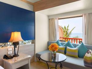 芭东海滩Novotel Phuket Resort的客厅配有蓝色的沙发和桌子