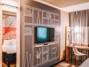 克尔斯特尔巴赫法兰克福机场宜必思酒店的一间设有电视和床的墙壁客房