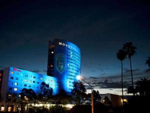 悉尼诺富特悉尼奥林匹克园大酒店的一座建筑物在晚上被蓝色的灯光照亮