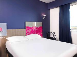 阿尔勒ibis Styles Arles Palais des Congrès的卧室配有白色的床和紫色墙壁