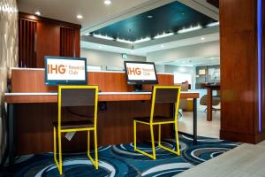 奥兰多Holiday Inn Express & Suites Orlando- Lake Buena Vista, an IHG Hotel的办公室里一张带两把椅子的高清书桌