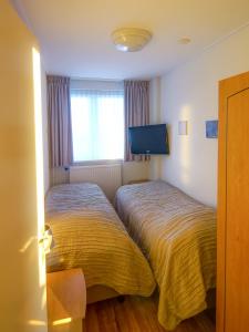 滨海卡特韦克Appartementen Zeezicht - 3的酒店客房设有两张床和电视。