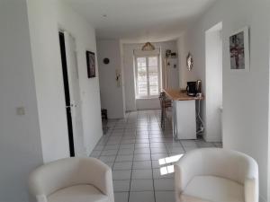 杜瓦讷内LE STUDIO DU RIS的走廊设有两把白色椅子和厨房