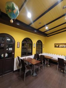 水里乡水里河堤咖啡民宿 Shuili Heti coffee B&B的一间设有桌椅的用餐室和黄色的墙壁
