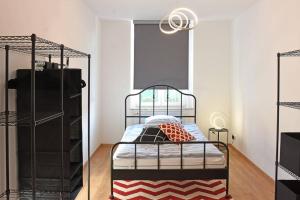茨维考stylish city apartment in Zwickau的卧室配有一张带红色和白色地毯的金属床