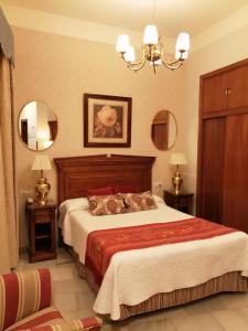 塞维利亚塞维利亚欧罗巴精品酒店的一间卧室配有一张大床和两面镜子