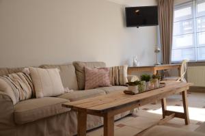 伊普尔Ciepers Lodge的带沙发和木桌的客厅