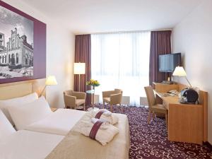 多特蒙德多特蒙得城美居酒店的配有一张床和一张书桌的酒店客房