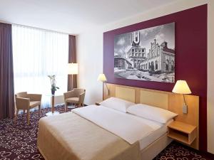 多特蒙德多特蒙得城美居酒店的酒店客房设有一张床,墙上挂着一幅大画