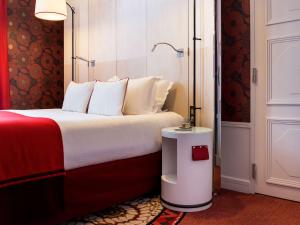 里昂Hotel Carlton Lyon - MGallery Hotel Collection的酒店客房,配有一张红色和白色的床