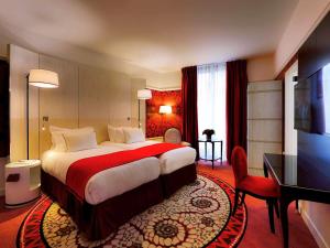 里昂Hotel Carlton Lyon - MGallery Hotel Collection的酒店客房设有一张大床和一张书桌。