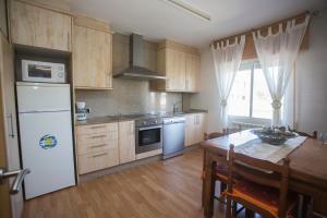 圣地亚哥－德孔波斯特拉纱黎拉公寓的厨房配有白色冰箱和木桌