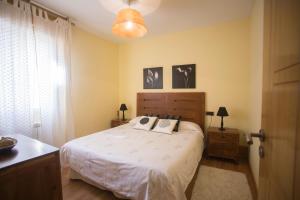 圣地亚哥－德孔波斯特拉纱黎拉公寓的一间卧室配有带白色床单和枕头的床。