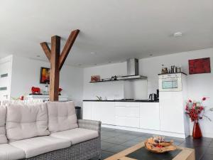 博文卡尔斯佩尔Markermeerlogies的一间带白色沙发的客厅和一间厨房