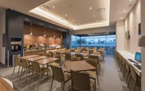 伊拉普阿托Microtel Inn & Suites by Wyndham Irapuato的一间带桌椅的用餐室和一间酒吧