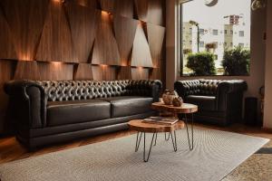 帕图布兰库Regente Hotel的客厅配有真皮沙发和桌子