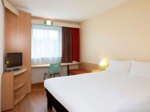 波兹南波兹南斯塔勒米亚斯托宜必思酒店的酒店客房设有一张大床和一台电视。
