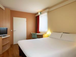 波兹南波兹南斯塔勒米亚斯托宜必思酒店的卧室配有一张白色大床和电视。