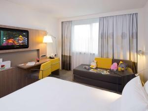 鲁汶诺富特勒芬中心酒店的一间酒店客房,配有一张床和一台电视