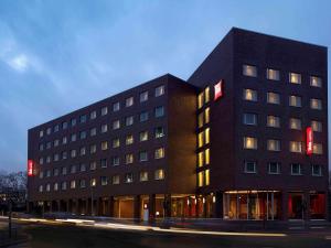 汉堡汉堡阿拉斯特瑞宜必思酒店的一座黑色的建筑,旁边设有红色标志