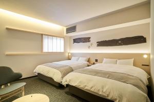 金泽凜庵 LIAN_KANAZAWA的一间卧室设有两张床、一把椅子和一个窗户。