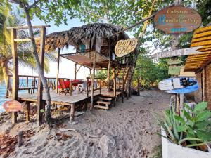 喀巴里特Cabarete Maravilla Eco Lodge Boutique Beach Surf, Kite, Yoga的海滩上的餐厅,配有桌椅