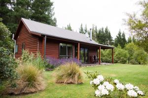 汉默温泉伍德兰公园度假屋的一座带花园和鲜花的小木房子