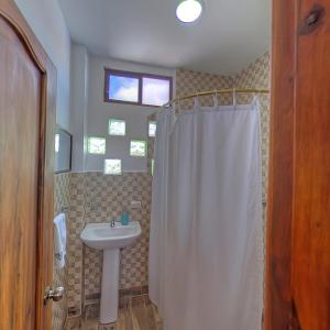 阿约拉港加拉帕戈斯梦酒店的浴室设有白色的淋浴帘和水槽