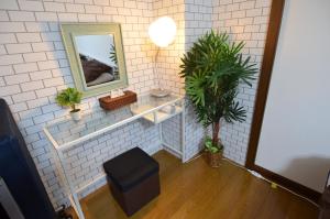 别府Comfort CUBE PHOENIX Beppu (やよいビル)的浴室设有镜子、凳子和植物