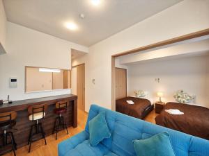 北谷町M´s Stay Okinawa的一间带蓝色沙发的客厅和一间卧室