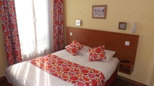 巴黎达拉普利斯德斯阿尔卑斯酒店的一间卧室配有红色和白色枕头的床