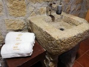 BempostaHouse Diogo的浴室内的石水槽,配有2条毛巾